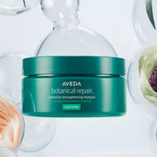 Aveda botanical repair jar on a white background with decorative elements