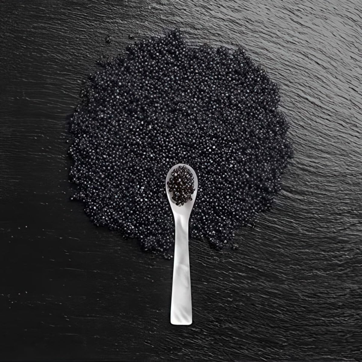 Black caviar on a black slate surface with a spoon