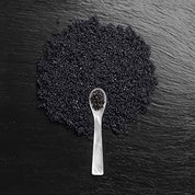 Black caviar on a black slate surface with a spoon